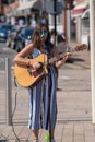 Dark haired female singer on street with sunglasses and