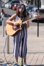 Dark haired female singer on street with sunglasses and