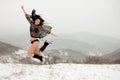 The dark-haired girl in a bathing suit in the winter jump mountains in the background Royalty Free Stock Photo