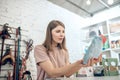 Dark-haired girl choosing nutriments for her pet in a pet store