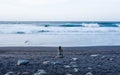 Dark-haired girl seen from behind looking at the sea. Strong waves in the Atlantic Ocean