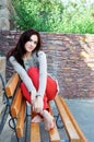 Dark-haired girl sitting on the bench Royalty Free Stock Photo