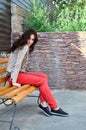 Dark-haired girl sitting on the bench Royalty Free Stock Photo