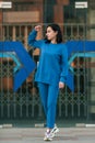 Dark-haired girl walks around the city and posing in a blue suit Royalty Free Stock Photo