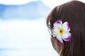 Dark haired girl wearing Hawaiian flower looking at ocean view Royalty Free Stock Photo