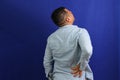 Dark-haired Latino adult man with neck, back and waist pain from trauma, injury or fracture Royalty Free Stock Photo