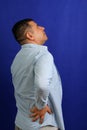 Dark-haired Latino adult man with neck, back and waist pain from trauma, injury or fracture Royalty Free Stock Photo