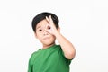 Dark haired little child with happy face smiling doing ok sign with hand on eye looking through fingers