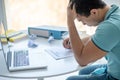 Dark-haired male sitting at his desk, filling in unemployment claim