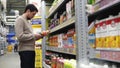 The dark-haired man gravely considering bottles with fruit juices.