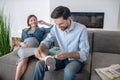 Dark-haired man taking off his wifes sneakers, woman smiling