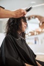 Dark-haired salon client napping during the hairstyling procedure