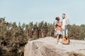 Dark-haired woman looking at her man while having rest in forest near big lake