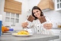 Dark-haired woman in a striped blouse holding two bars of chocolate Royalty Free Stock Photo