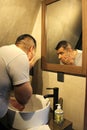 Dark-haired 40-year-old Latino man does his beauty routine, shaves with shaving cream and soap to avoid folliculitis