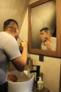 Dark-haired 40-year-old Latino man does his beauty routine, shaves with shaving cream and soap to avoid folliculitis