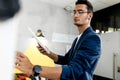 Dark-haired young architect dressed in blue checkered jacket works in the modern office Royalty Free Stock Photo