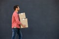 Dark-haired young man in eyeglasses carrying carton boxes Royalty Free Stock Photo