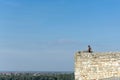 Young man overseeing the cityscape from the ancient stone watchtower