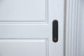 Dark handle on the white facade of the cabinet. Furniture fittings. Royalty Free Stock Photo