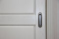 Dark handle on the white facade of the cabinet. Furniture fittings. Royalty Free Stock Photo