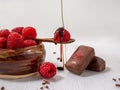 Dark handmade chocolate with raspberries and syrup