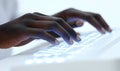 Dark hands typing on illuminated keyboard Royalty Free Stock Photo