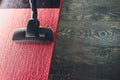 Dark head of a modern vacuum cleaner being used while vacuuming a rug. Cleaning service concept. Process carpet with Royalty Free Stock Photo