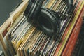 dark headphones lay on stack of retro vinyl records b