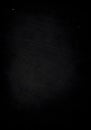 A completely dark image with some very slight variations in shade and some tiny white specks visible
