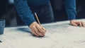 In the Dark Industrial Design Engineering Facility: Male Engineer Works with Blueprints Laying on Royalty Free Stock Photo