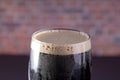A dark Irish dry stout beer glass close up view
