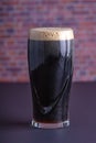 A dark Irish dry stout beer glass that originated in the brewery in dublin