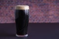 A dark Irish dry stout beer glass that originated in the brewery in dublin