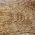 Dark lacquered veined wood surface top view, brown textured background.