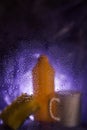 On a dark lilac background. Close-up of household cleaning products and kitchen accessories. View through fogged glass