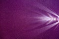 On a dark lilac structural fine-grained background, a light purple scattered beam of light