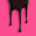 Glossy Black Liquid Dripping on Pink Background Royalty Free Stock Photo