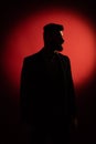 Dark male silhouette. Silhouette of man with beard over red background with copy space