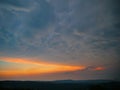 Dark mammatus clouds gather above the peaceful countryside at golden sunset.