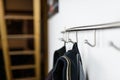 Dark mens jackets hanging on a hook in hause, on a wall hanger.
