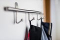 Dark mens jackets hanging on a hook in hause, on a wall hanger.