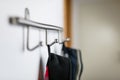 Dark mens jackets hanging on a hook in hause, on a wall hanger.