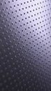 Dark metallic phone wallpaper. Perforated aluminum surface with many holes. Tinted violet or purple technological background.