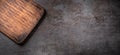 Dark metallic surface with a rectangular empty wooden cutting board in top left corner Royalty Free Stock Photo