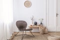 Dark, modern wicker chair in a white living room interior with a wooden bench and decorations made from natural materials Royalty Free Stock Photo