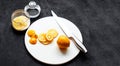 Dark moody. Food black background. On a white stone board in the hands of a girl, a knife cuts a lemon. Slices of lemon are piled Royalty Free Stock Photo