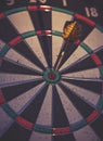 A dark moody image of a dartboard with a dart in the center bull Royalty Free Stock Photo