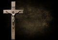 Dark mottled brown and black tones with body of Christ on wooden cross Royalty Free Stock Photo