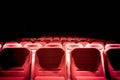 Dark movie theater with projection light and empty red seats Royalty Free Stock Photo